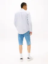 Camisa celeste de algodón Oxford, corte regular, cuello abotonado, puños redondeados con botón, logo de Tommy Jeans bordado en el pecho.