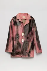 Blazer de cuero color rosa con manchas negras, con cuello clásico, cierre con dos botones y bolsillos frontales.
