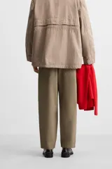 Pantalón de hombre color beige, corte carrot fit, con cintura elástica ajustable con cordón, bolsillos frontales y bolsillo trasero de plastrón.