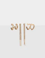 Set de tres pares de aros dorados: argollas con forma de corazón con strass, argollas clásicas y aros colgantes con lluvia de strass.