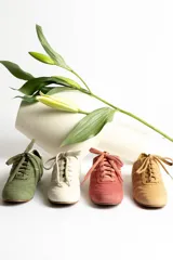 Zapatillas acordonadas color beige con detalles en blanco.