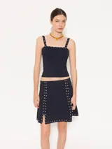 Top negro ajustado al cuerpo, con breteles finos y detalle de piedras en el escote.