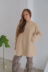Buzo color beige de tejido plano tipo cashmiere, corte holgado y mangas largas.