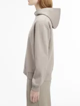 Buzo con capucha Calvin Klein color beige, confeccionado en felpa suave de algodón orgánico y poliéster reciclado. Tiene puños y dobladillo con punto canalé y logo nano en el pecho.
