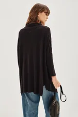 Cárdigan color beige de tejido suave, con calce relajado y largo irregular.