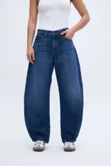 Jean azul de tiro alto, corte holgado tipo globo desde la cadera hasta la rodilla, estrechándose hacia el bajo.