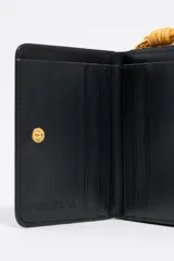 Monedero negro de piel con logo Bimba y Lola estampado, estructura rígida, acabados metálicos dorados, tarjetero interior y cierre de presión.