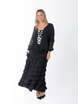 Falda larga negra con cintura elástica y múltiples volados horizontales.