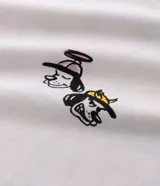 Remera blanca de algodón con cuello redondo y mangas cortas. Presenta un estampado estilo grafiti en la espalda con lettering en amarillo y rosa, y la ilustración de un perro con gorra y aerosol.