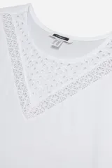 Remera blanca de algodón con cuello redondo y mangas cortas. Presenta detalle de broderie en forma de V en el escote.