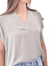 Blusa negra de manga corta con cuello mao y abertura en V con un botón.
