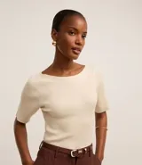 Blusa de punto color crema con escote bote y mangas cortas.
