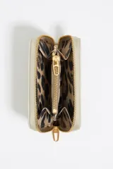 Monedero Bimba y Lola color gris claro, de nylon con estructura blanda. Tiene logo metálico de la marca, cierre con cremallera, tarjetero y monedero interior.