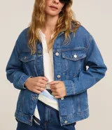 Campera trucker de jeans azul oscuro, corte amplio, con cuello clásico, cierre frontal con botones blancos, mangas largas y bolsillos delanteros con solapa.
