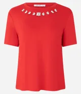 Blusa roja de mangas cortas confeccionada en viscosa con cuello redondo con apliques brillantes en formas florales.