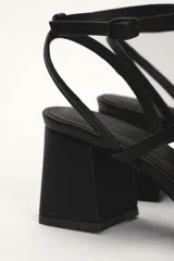 Sandalia dorada de cuero con tiras finas, punta cuadrada y taco bloque.