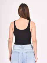 Musculosa corta marrón de morley con breteles finos y estampado de una estrella blanca en el centro.