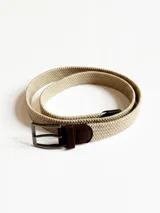 Cinto beige de tejido trenzado con hebilla metálica rectangular y apliques de cuero marrón.