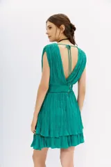Vestido corto color fucsia con escote en V, sin mangas y falda con volados.