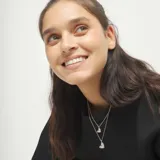 Collar de dos cadenas de aleación de metales bañadas en plata de ley, con dos dijes de corazón colgantes de diferente tamaño.