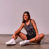 Musculosa deportiva negra con estampado de líneas diagonales blancas y logo de New York en el pecho.
