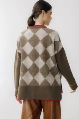 Cárdigan color beige con patrón de rombos en tonos marrones, cierre con botones, bolsillos frontales y bordados de cerezas.