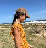 Musculosa tejida color marrón con diseño calado y flecos en los hombros.