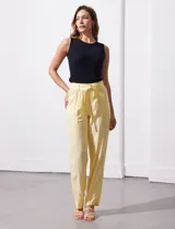 Pantalón de lino color amarillo con pretina ancha, pasadores y lazo de ajuste.
