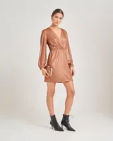 Vestido corto de fiesta color cobre metalizado, con escote en V cruzado, mangas largas abullonadas con puños elásticos y falda recta.