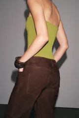 Body bandeau color verde oliva confeccionado en tejido elástico, con escote recto y hombros descubiertos. Cierre inferior con botones a presión.