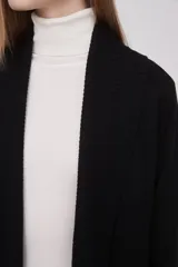 Saco negro de viscosa con textura acanalada, corte holgado y mangas largas.