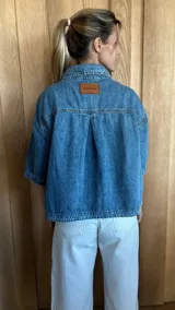 Sobrecamisa color gris oscuro de denim suave, con cuello clásico, cierre frontal con botones, mangas cortas y dos bolsillos de parche en el pecho.