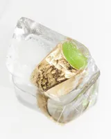 Anillo dorado de acero quirúrgico hipoalergénico con forma irregular y piedra central verde.