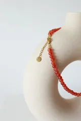 Collar corto de cuentas redondas de vidrio color naranja.