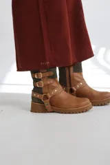 Botas cortas de gamuza color marrón con detalles dorados y hebillas decorativas.