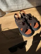 Sandalias negras de charol con tiras cruzadas y plataforma track.