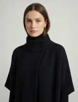 Capa tejida color fucsia, con cuello alto abotonado y mangas cortas estilo japonesa. Tejido de punto grueso.