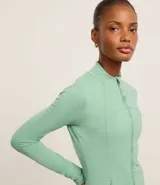 Campera deportiva color verde agua, confeccionada en microfibra, con cierre frontal, cuello alto, recortes en el frente y bolsillos laterales.