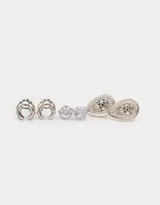 Set de tres pares de aros pasantes plateados con diferentes diseños: un par con forma de medialuna con strass, un par con circonita engarzada y un par con forma de lágrima con strass.