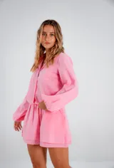 Conjunto rosa de lino, compuesto por una camisa de manga larga con corte holgado y un short de tiro alto.