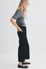 Pantalón de jean negro de corte ancho, tiro alto y largo cropped.