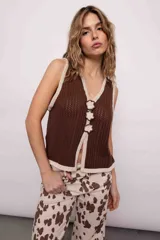 Chaleco tejido marrón con escote en V y detalle de flores en crochet color crema.