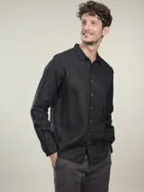 Camisa negra de lino con cuello clásico, manga larga y cierre frontal con botones. Corte recto.