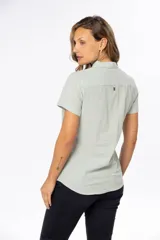 Camisa color salmón de lino, de corte clásico, con cuello camisero, manga corta, cierre frontal con botones y dos bolsillos de parche en el pecho.