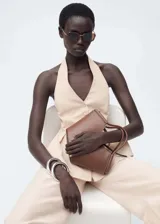 Chaleco color crema con cuello halter y peplum. Cierre frontal con botones.