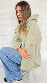 Campera color ocre con capucha y cierre frontal asimétrico.