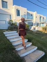 Pollera corta de lino color marrón oscuro (chocolate), con volado en el ruedo y corte ajustado.