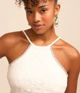 Blusa cropped blanca de encaje con cuello halter, breteles finos con lazo en la espalda y lastex en la espalda.