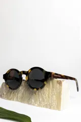 Lentes de sol redondos con montura de carey y lentes oscuros.