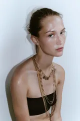Set de tres collares dorados con dijes y abalorios.